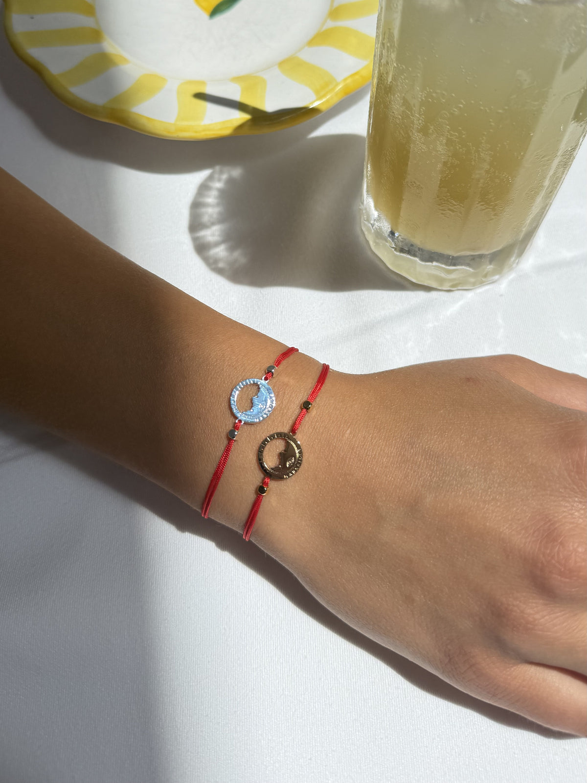 Deux bracelets Les Catalans cordon nylon rouge portés ensemble, une médaille Marseille plaquée argent et une dorée à l'or fin — Ligne Bleue, Marseille