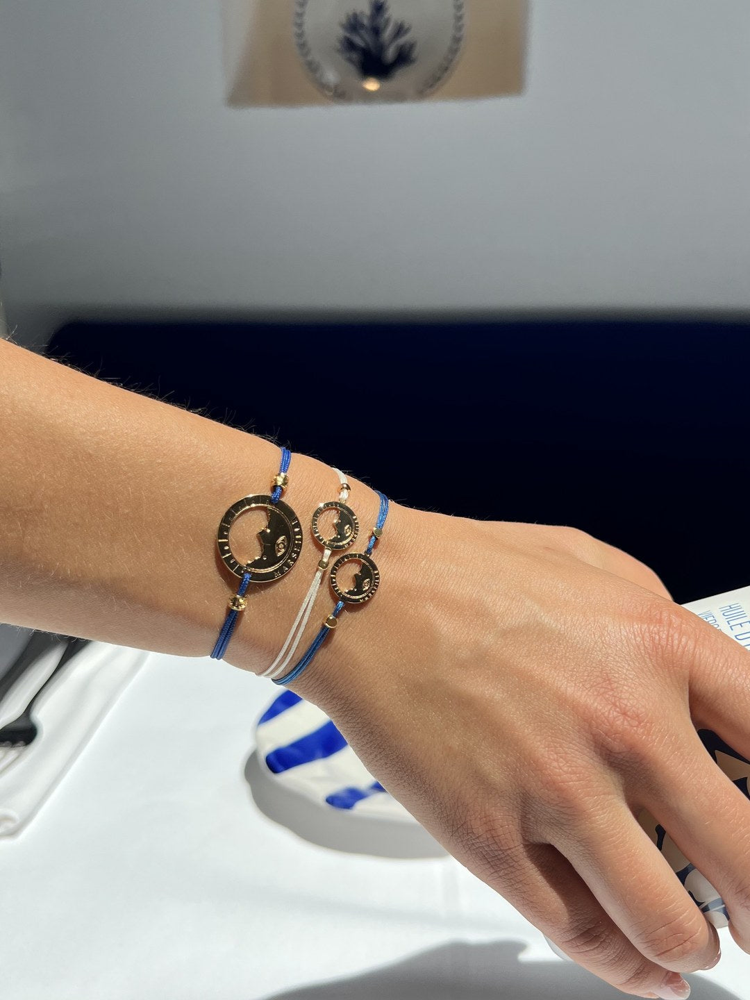 bracelet Pointe Rouge cordon bleu Klein doré porté au poignet — grande médaille Marseille ajourée, Ligne Bleue