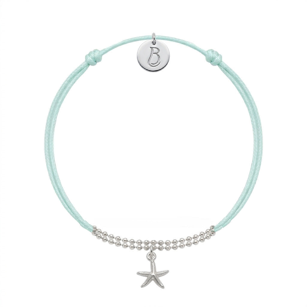 Bracelet Le Vallon des Auffes en plaqué argent 10 microns, cordon bleu lagon, étoile de mer devant et médaillon au monogramme LB au creux du poignet — Ligne Bleue, Marseille