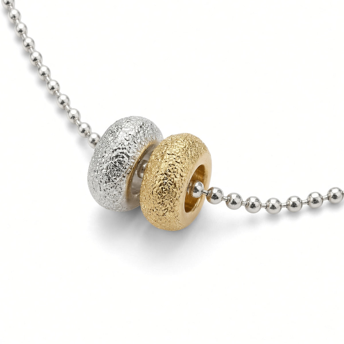 Détail des deux donuts du collier Les Goudes, l'un doré à l'or fin 24 carats, l'autre plaqué argent 10 microns, sur chaîne boule diamantée en plaqué argent 10 microns — Ligne Bleue, Marseille