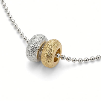 Détail des deux donuts du collier Les Goudes, l'un doré à l'or fin 24 carats, l'autre plaqué argent 10 microns, sur chaîne boule diamantée en plaqué argent 10 microns — Ligne Bleue, Marseille